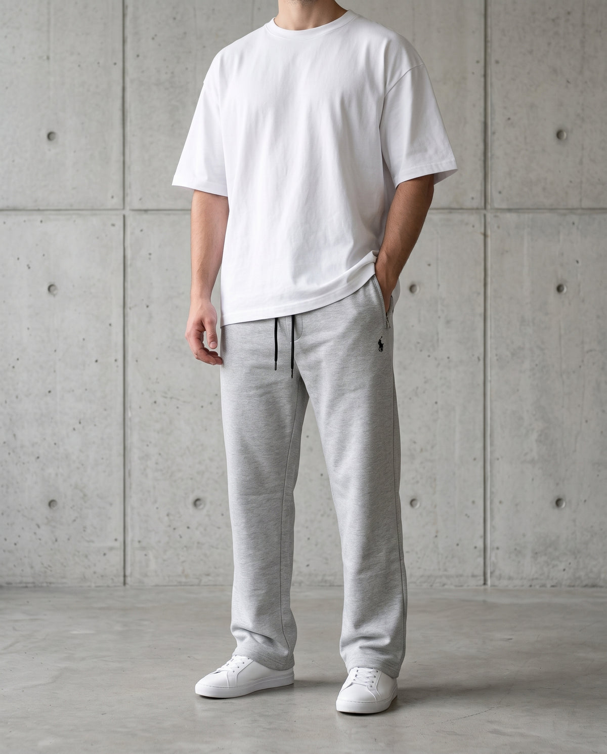 Grey cotton terry trousers worn with a white tee, relaxed straight-leg fit
