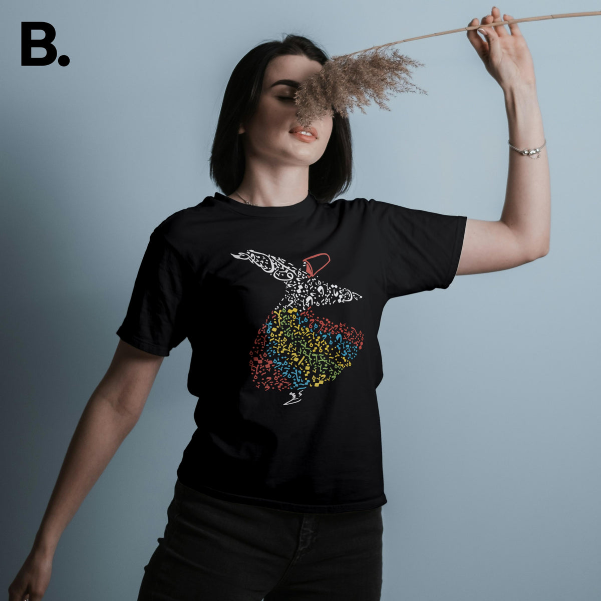 Model wearing the black Sufi tee with a multicoloured whirling calligraphy figure