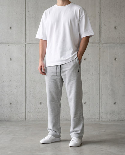 Grey cotton terry trousers worn with a white tee, relaxed straight-leg fit