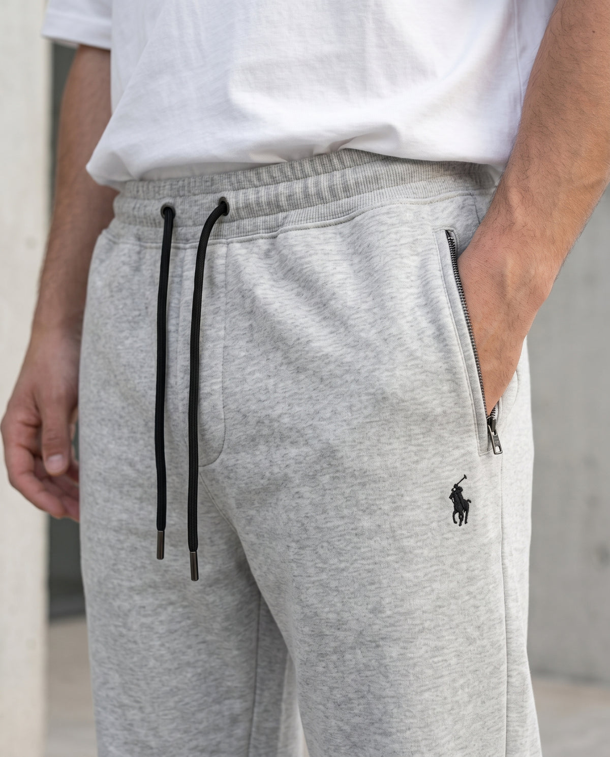 Close-up of the drawstring waistband and zippered pocket on Grey cotton terry trousers